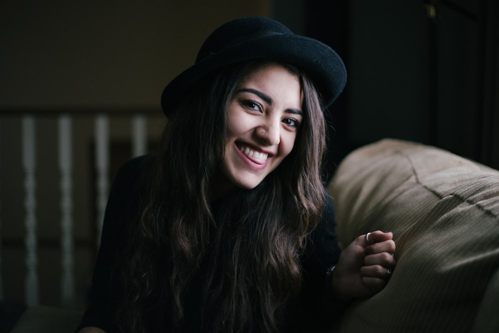 Mujer sonriendo mientras está sentada en el sofá