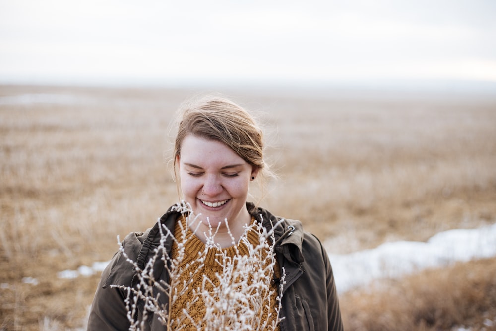 woman smiling near flower during faytime