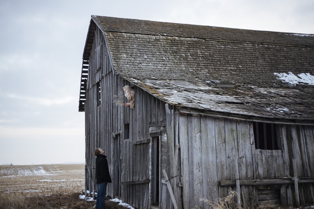 photo of man standing and looking woman in house