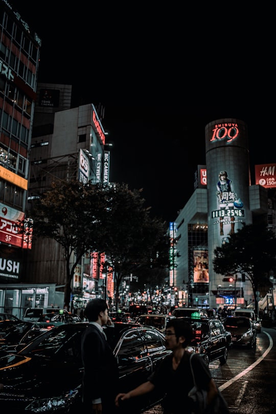 man standing near black sedan in Shibuya Crossing Japan