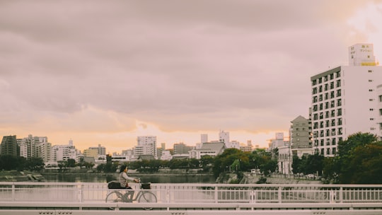 person riding bike on bridge in Hiroshima Japan