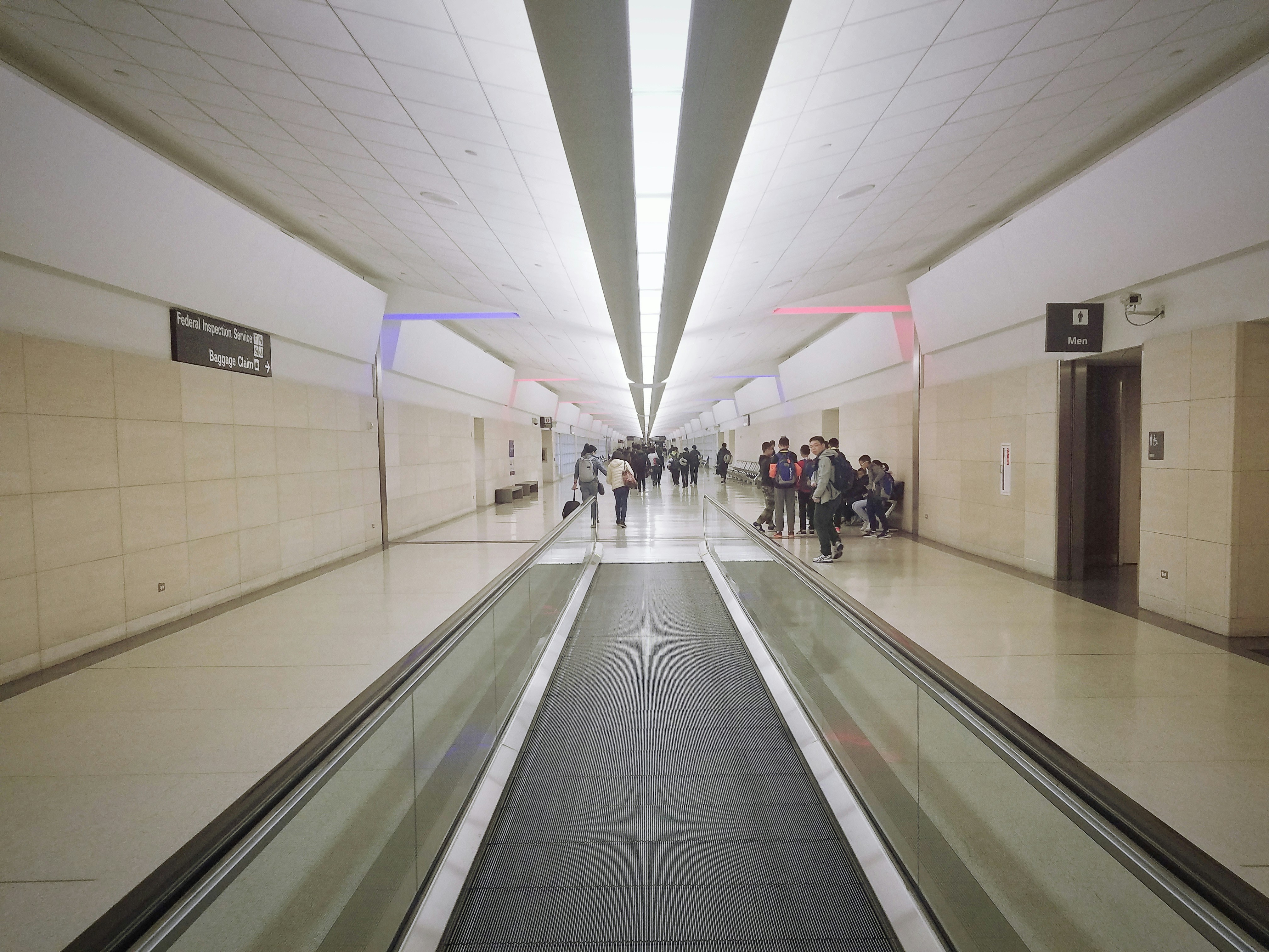 people walking on hallway with white wall, 