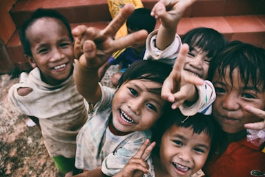 perspective and angle for photo composition,how to photograph happiness of the poor children.
 taken in chupah district, gialai province vietnam.; five children smiling while doing peace hand sign