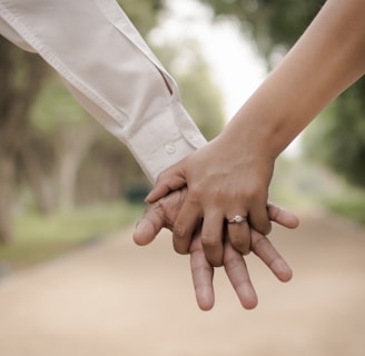 shallow focus photography of two person holding hands