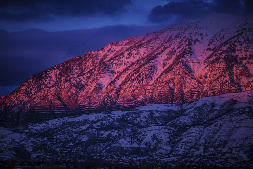 montanha coberta de neve sob céu nublado durante a noite