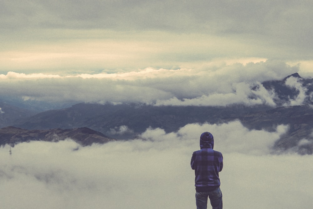 person looking at sea of clouds during daytime