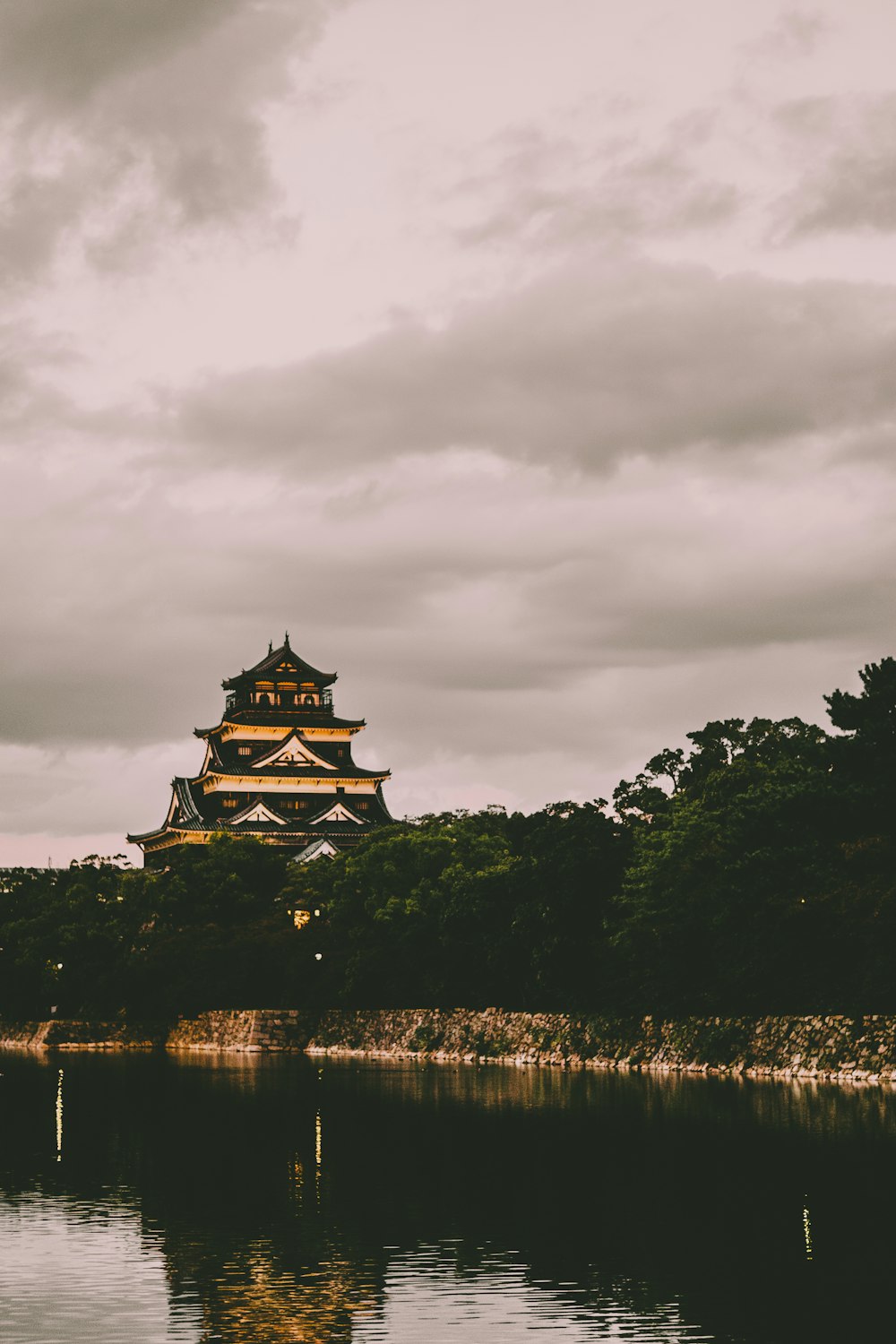 a tall building sitting on top of a lush green hillside