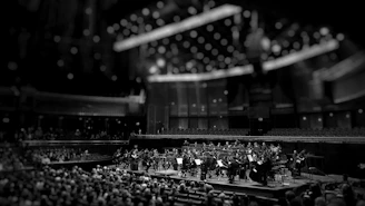 grayscale photography of orchestra playing on theatre