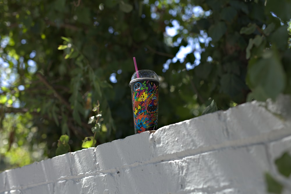 shallow focus photography of cup with straw on concrete surface