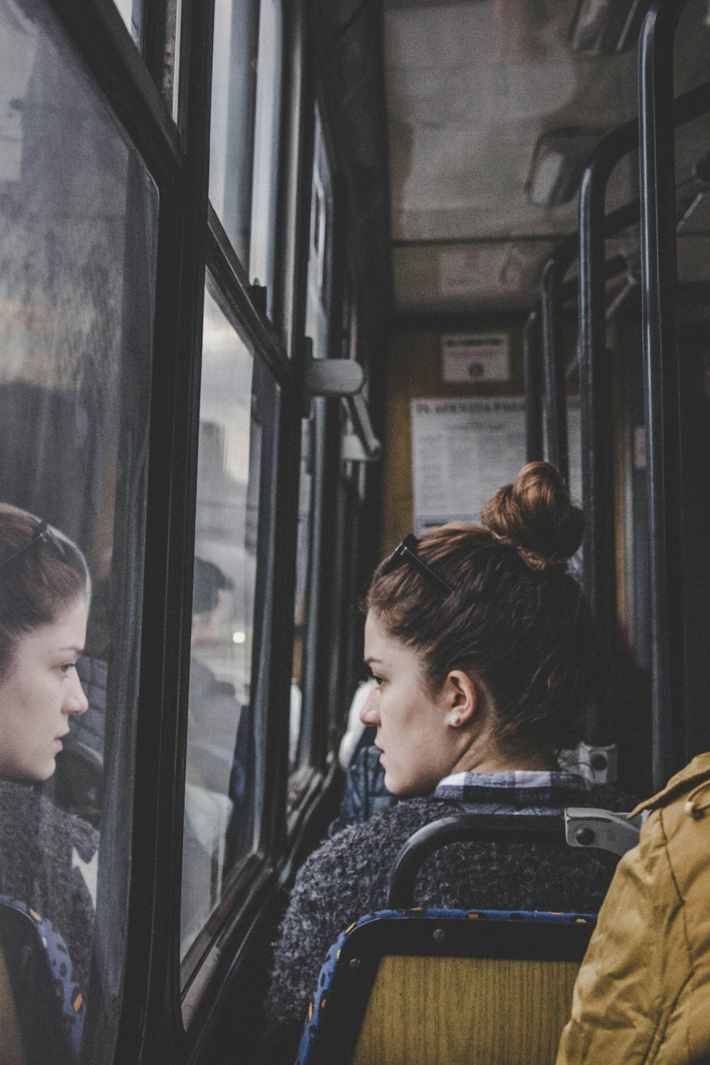 Mujer en la parte superior gris sentada en el asiento del pasajero