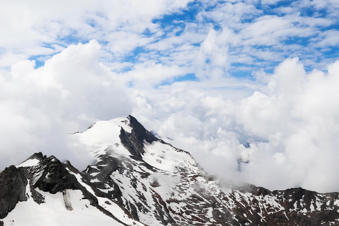 mountain covered with snow and white clouds during daytime