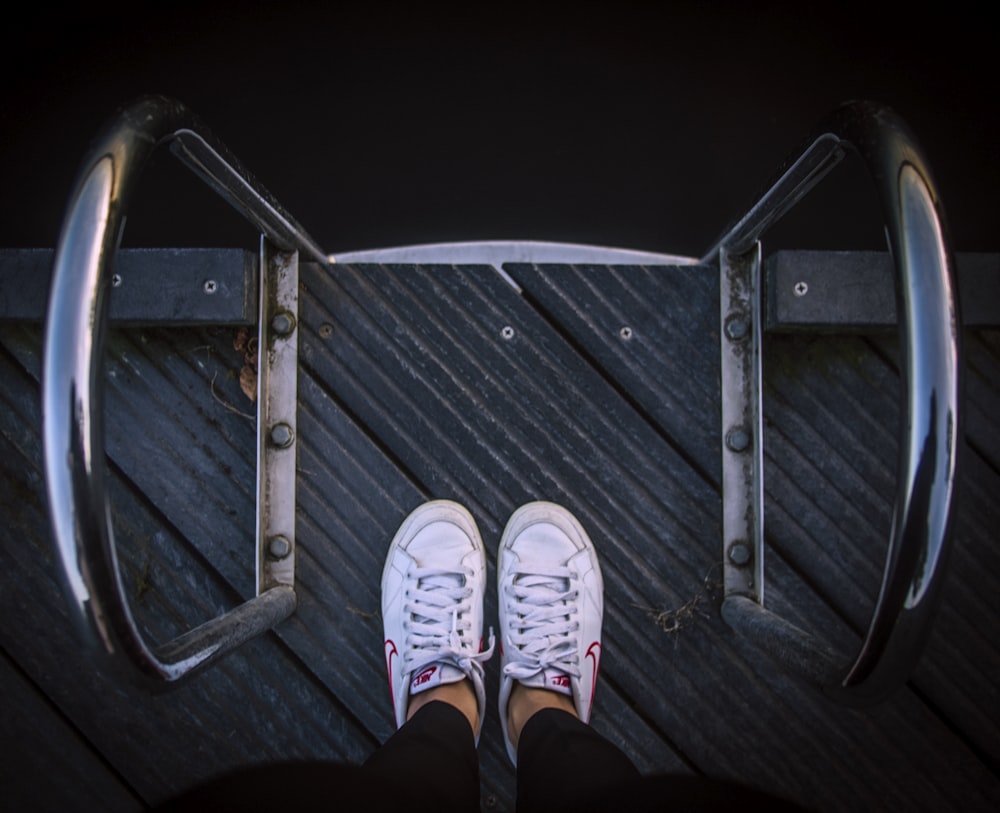 person wears pair of white low-top sneakers