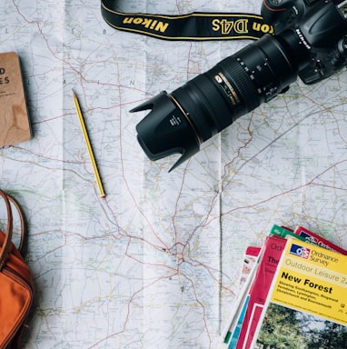 flat lay photography of camera, book, and bag