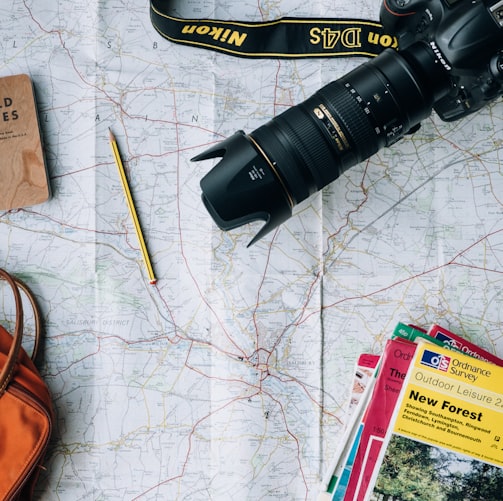 flat lay photography of camera, book, and bag