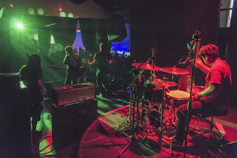 Energetic band performing live on stage with vibrant lighting.