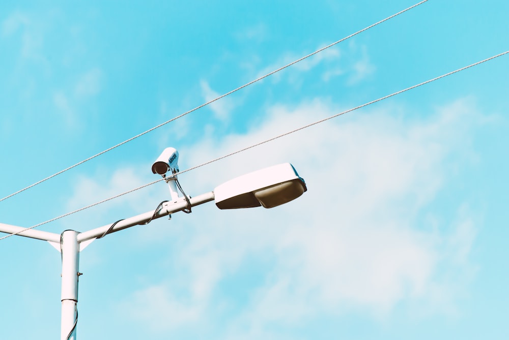 closeup photo of white lamp post and camera