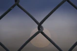 Wide shot of a property's perimeter fence highlighting potential weak spots at dusk.
