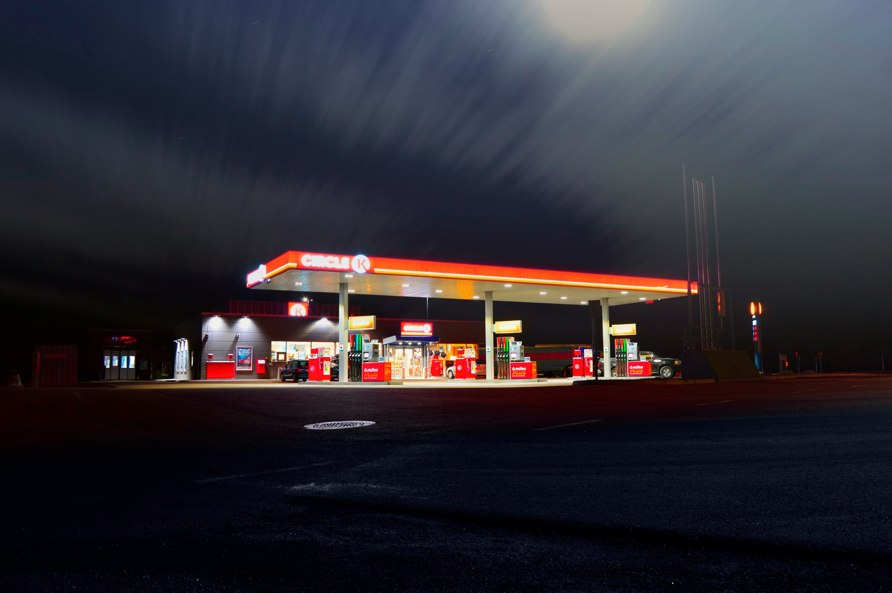 Circle gas station along the road during night time