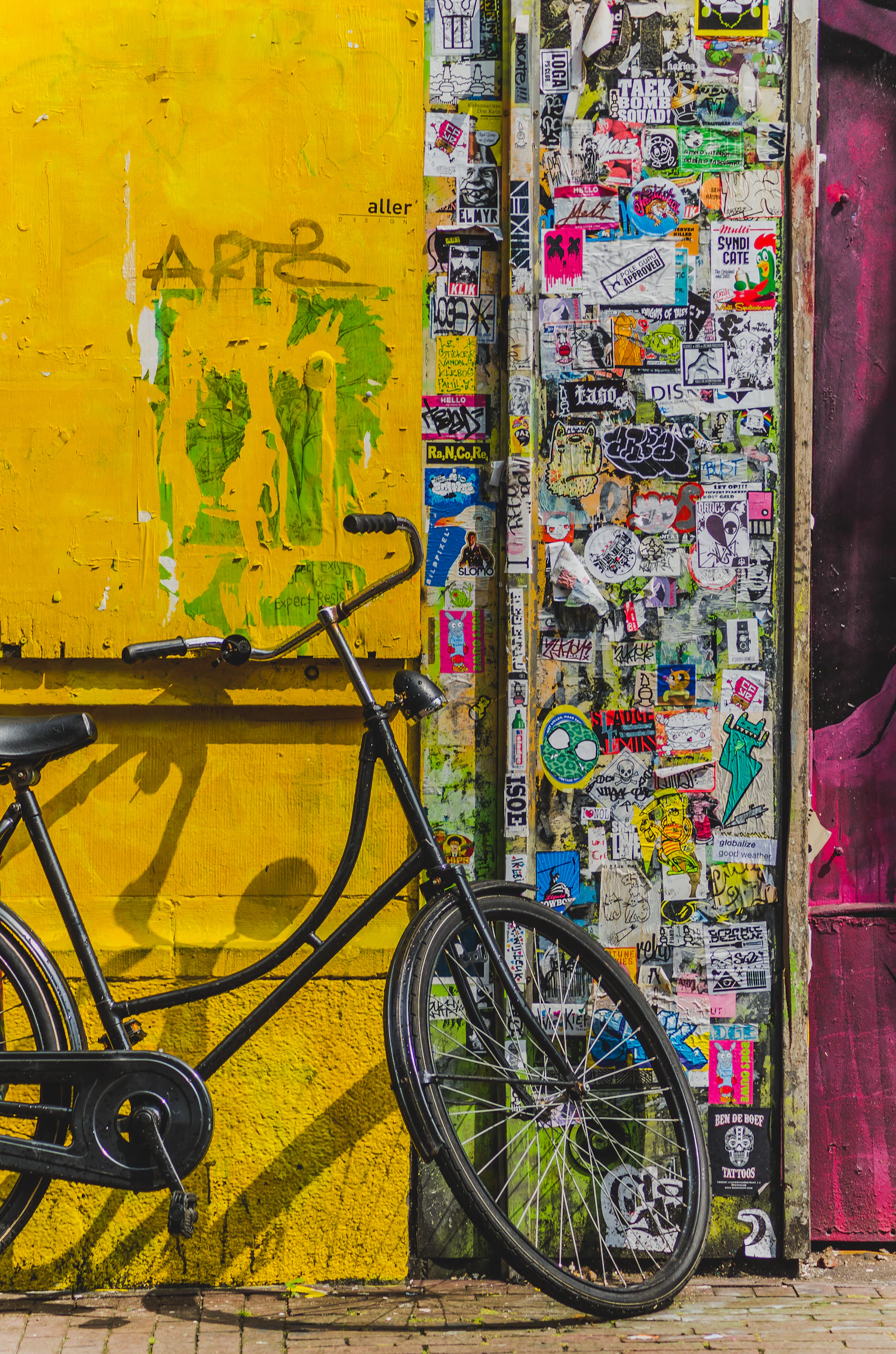 A bicycle against a colourful wall covered in street art