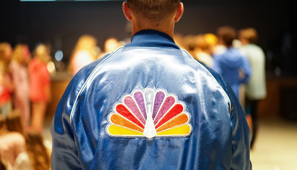 man wearing blue jacket standing in front of people