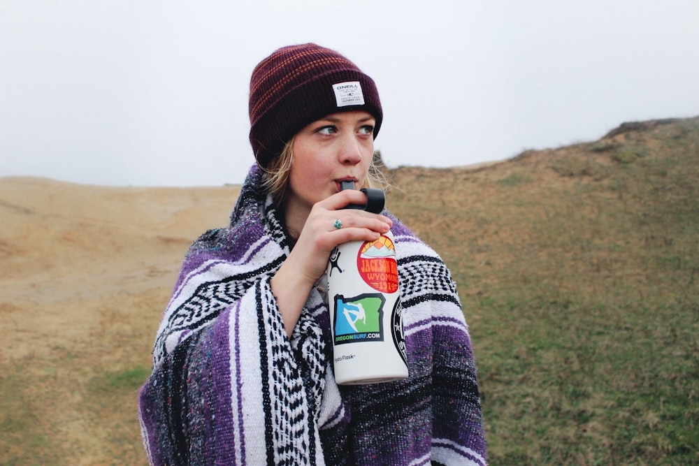 woman drinking on white bottle