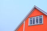 Exterior shot of a house flip with fresh navy blue siding and bright orange door.