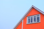 Completed house exterior showcasing fresh renovation with blue and orange accents.