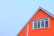 Condominium exterior showing a clean, well-protected roof with subtle orange accents.