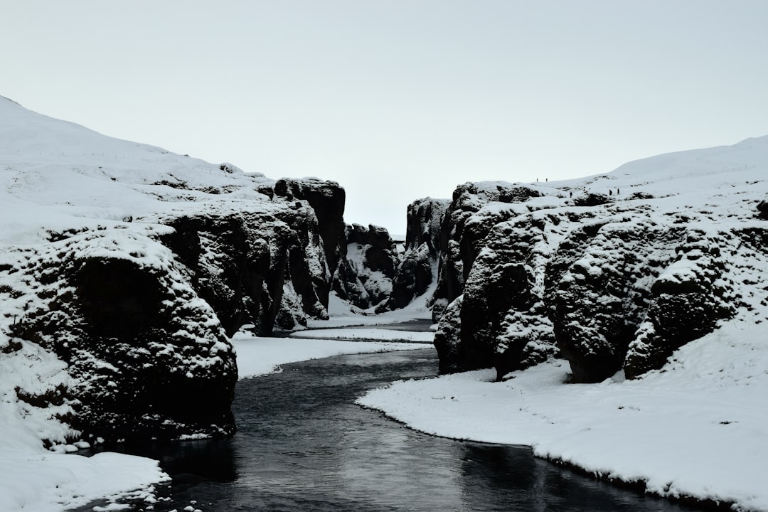 body of water between snowy mountains