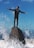 man standing on rock surrounded by water
