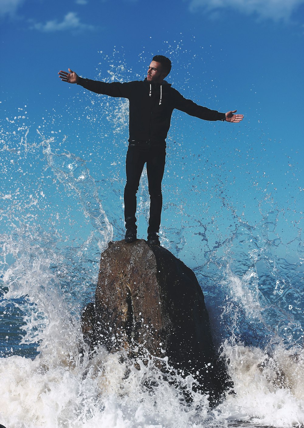물에 둘러싸인 바위 위에 서 있는 남자