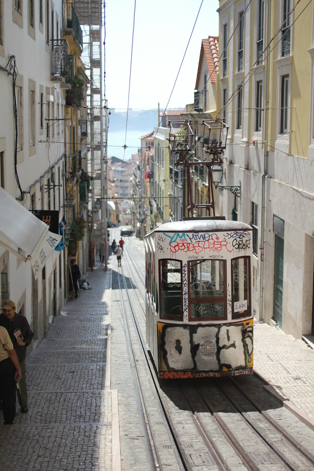 gray tram on railway along the building