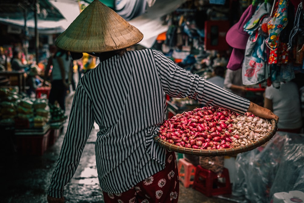 femme portant un panier avec des légumes