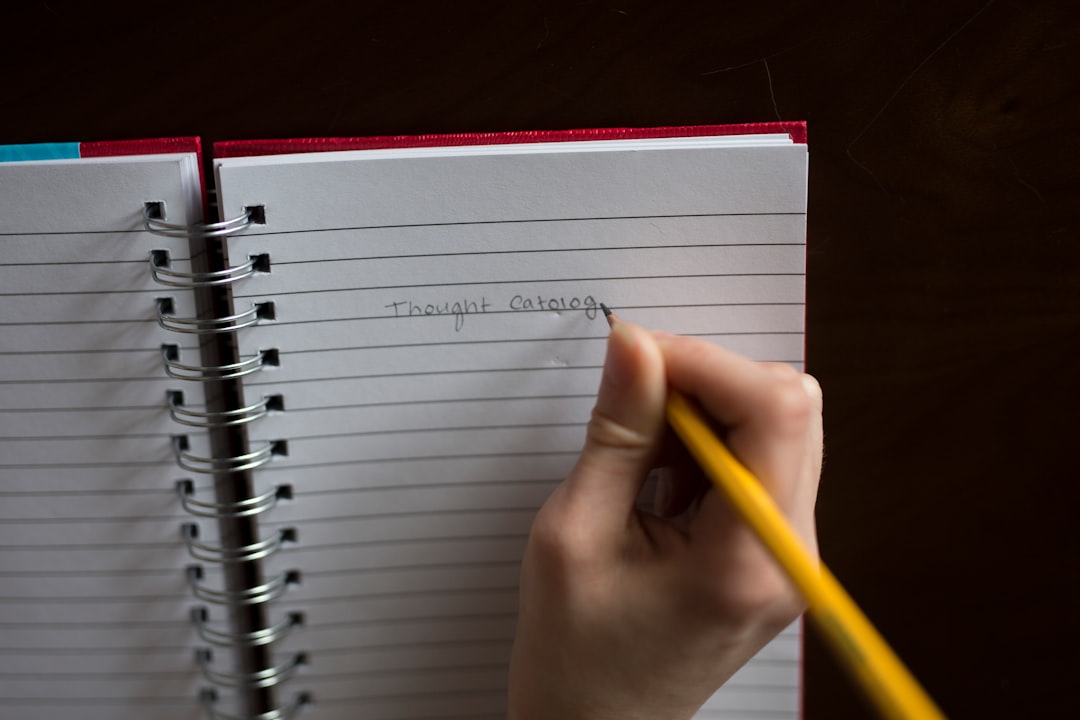 person writing on notebook