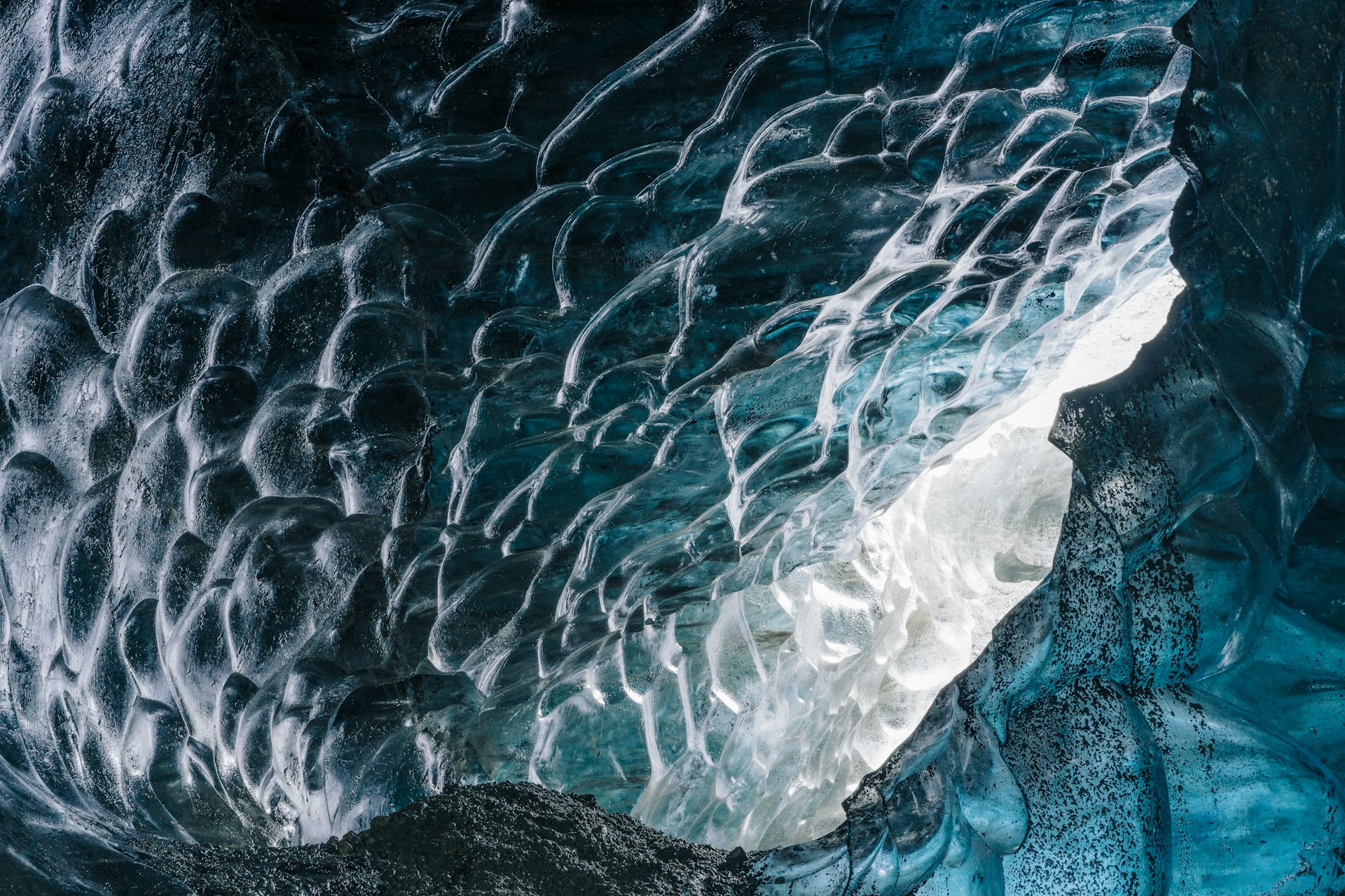 a large ice cave with water flowing down it