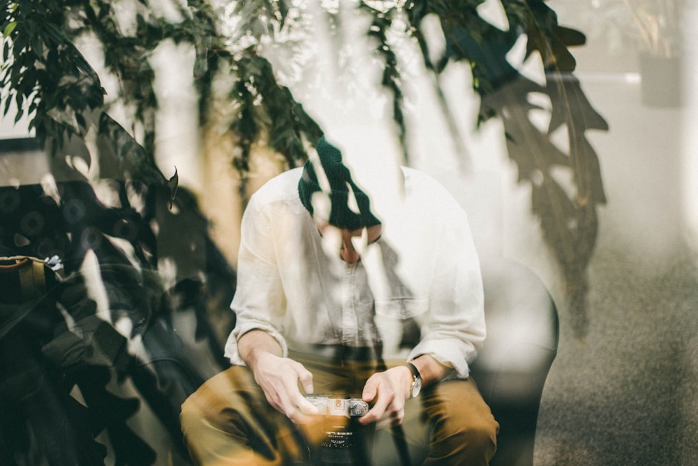 man sitting on chair using camera