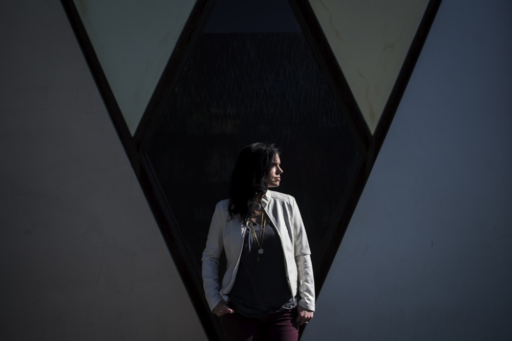 woman standing behind black wall while looking right side