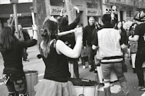 A group of diverse students enjoying a drum lesson together, smiling and engaged.
