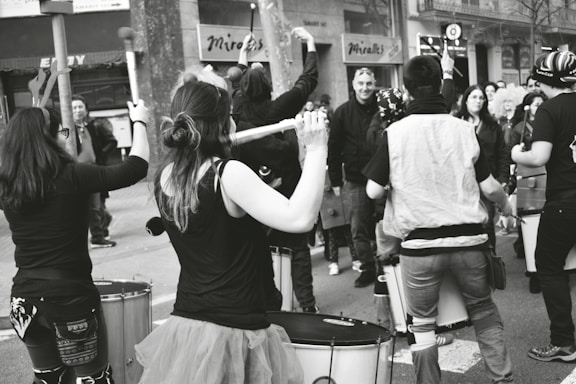A warm, inviting photo of a community music workshop with diverse people playing instruments together.