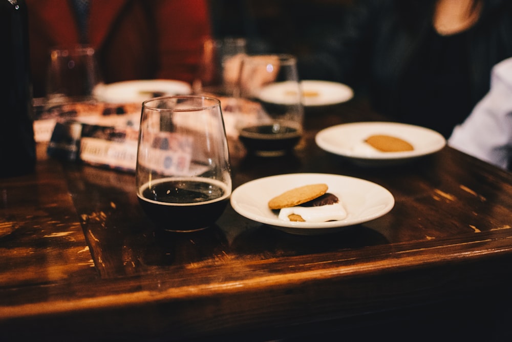 Photo de mise au point sélective d’une assiette avec de la nourriture à côté de la verrerie sur la table