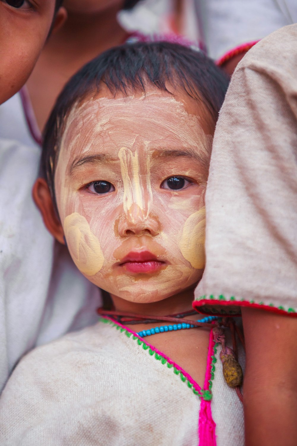 child with beige face paint