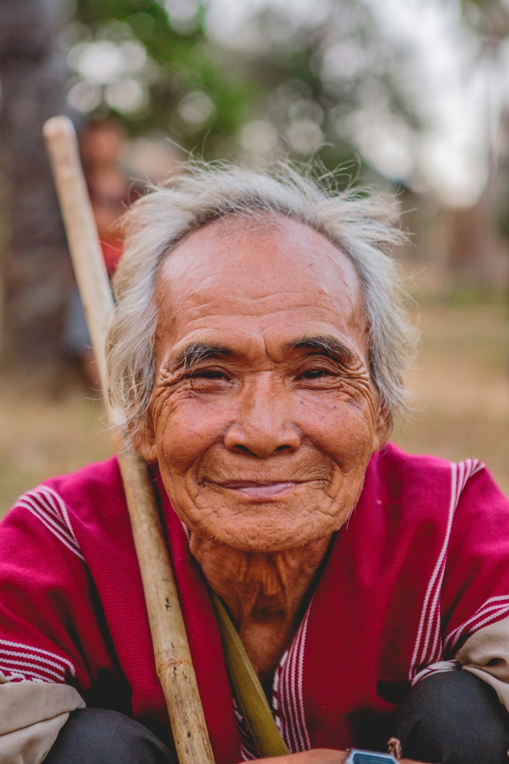 hombre sosteniendo un palo marrón sonriendo