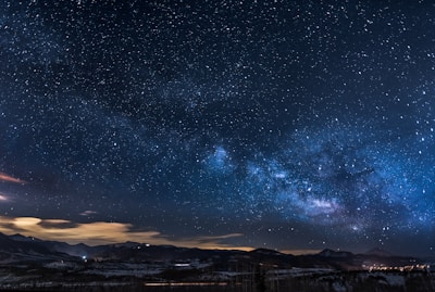 mountains with trees under white star at night