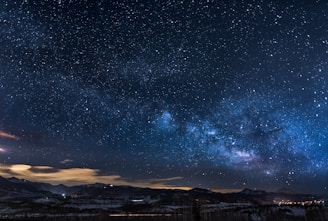 A breathtaking view of a starry night sky with a glowing Milky Way stretching across the horizon.