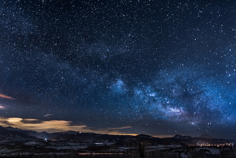 mountains with trees under white star at night