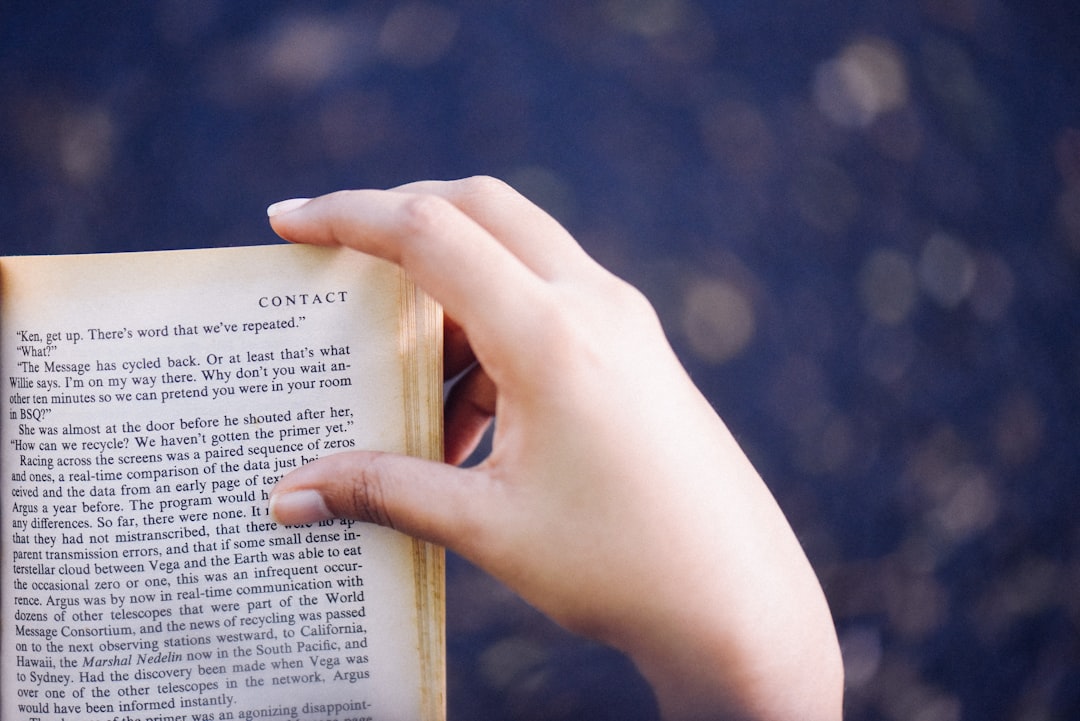 Hand on book page corner
