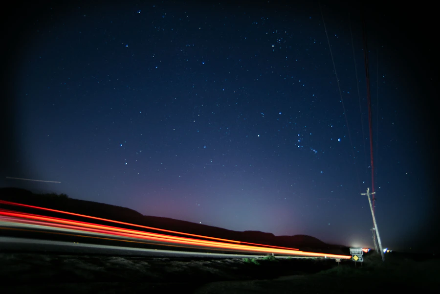 Light trails on a road under a starry sky