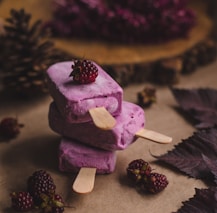 selective focus photography of thee purple ice pops near pine cones