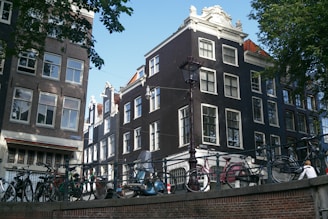 A cozy street scene in Amsterdam with bicycles and canal houses in soft morning light.