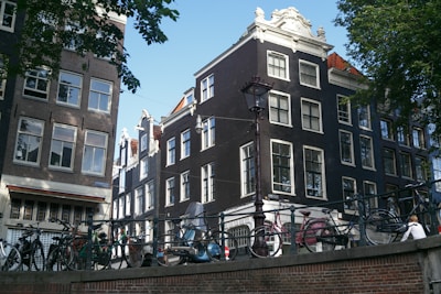 A cozy street scene in Amsterdam with bicycles and canal houses in soft morning light.